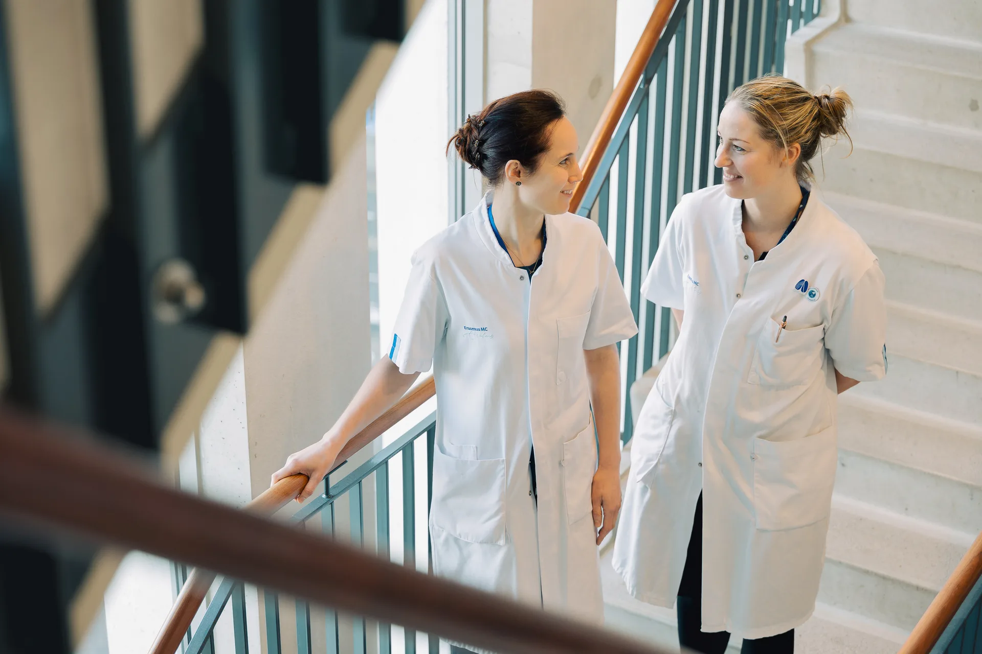 Deux soignantes de l'Erasmus MC en discussion dans l'escalier de l'hôpital — reportage de santé